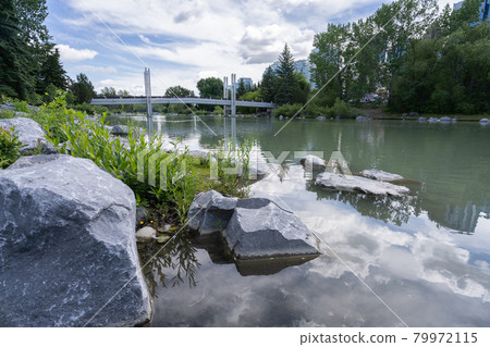 City park scenery with river and bridge crossing it, shot in Princes Island Park, Calgary, Alberta, Canada City park scenery with river and bridge crossing it, shot in Princes Island Park, Calgary, Alberta, Canada 79972115