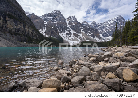 Beautiful alpine lake with turquoise waters surrounded by magnificent peaks, low perspective shot made on a overcast day at Moraine Lake, Banff 79972137