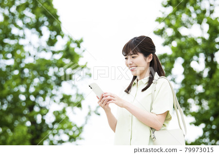 Female smartphone search smile outdoor 79973015