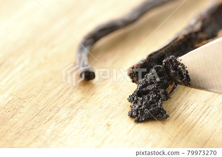 用刀將香草豆從豆莢上刮下來 用刀將香草豆從豆莢上刮下來 79973270