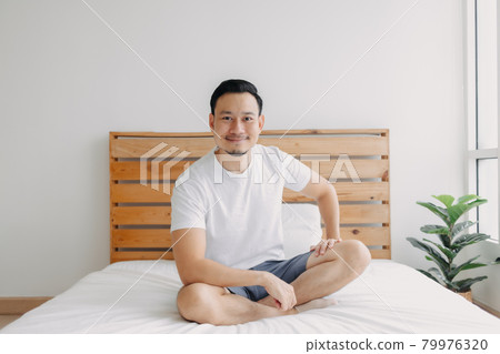 Happy man chilling and relaxed on his bed. Concept of a healthy mind. Happy man chilling and relaxed on his bed. Concept of a healthy mind. 79976320