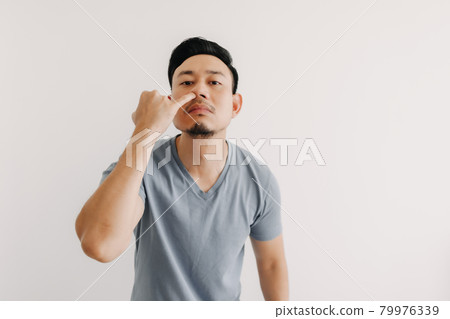 Man is picking his nose isolated on white background. Man is picking his nose isolated on white background. 79976339