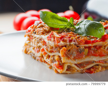 Extra close up view to piece of lasagna with basil 79999779