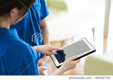 Caregiver viewing materials on tablet Caregiver viewing materials on tablet 80028750