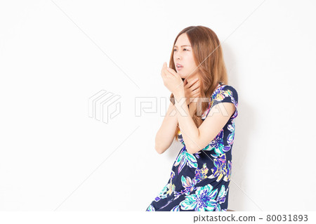 A young woman in a blue one-piece, making a sore throat gesture in front of a white wall A young woman in a blue one-piece, making a sore throat gesture in front of a white wall 80031893