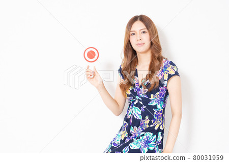 A young woman in a blue one-piece, holding an OK placard in front of a white wall A young woman in a blue one-piece, holding an OK placard in front of a white wall 80031959