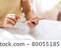 Smile happy young asian woman relaxing and using smart phone in the morning at home 80055185