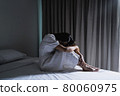 Lonely young woman feeling depressed and stressed sitting in the dark bedroom, Negative emotion and mental health concept 80060975