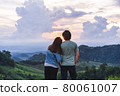 Happy young couple traveler relaxing and looking at the beautiful sunset on the top of mountain 80061007