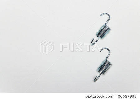 Two short metal springs for repairing the brakes of the machine. 80087995