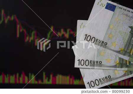 Hands holding euro, EUR in front of a laptop monitor with a price chart.Forex and trading.A trader trades stocks,bonds and securities or currencies on the Forex market or stock exchange for euro 80099230