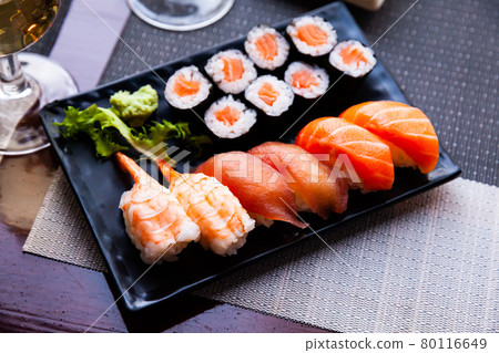 Various sushi served on black plate. Japanese food 80116649