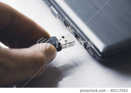 Hand inserting USB (Universal Serial Bus) Type A version 3.0 connecting to usb port of laptop Hand inserting USB (Universal Serial Bus) Type A version 3.0 connecting to usb port of laptop 80117083