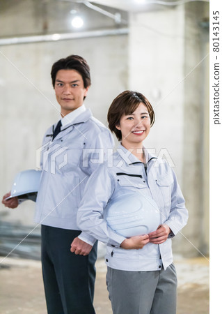 Two men and women involved in construction to look around the construction site 80143145