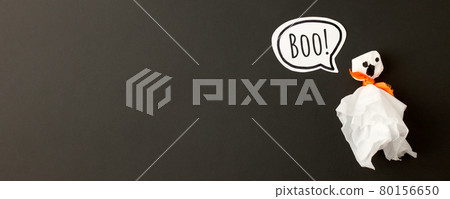 Happy Halloween holiday concept. Simple papercraft ghost from napkin on black background. Halloween party greeting card, invitation, banner. Spelling word Boo Flat lay, top view, overhead Happy Halloween holiday concept. Simple papercraft ghost from napkin on black background. Halloween party greeting card, invitation, banner. Spelling word Boo Flat lay, top view, overhead 80156650