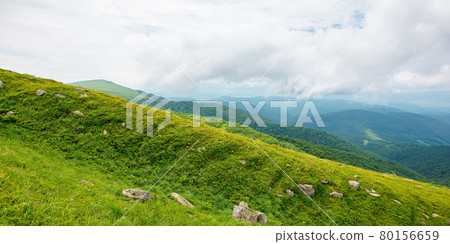summer mountain landscape. beautiful nature scenery. stones on the grassy hills rolling in to the distant ridge beneath a cloudy sky. travel back country concept 80156659