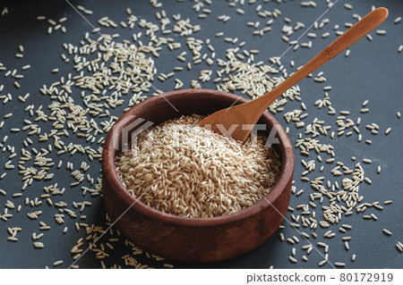 Brown rice in a wooden bowl with wooden or bamboo spoon Brown rice in a wooden bowl with wooden or bamboo spoon 80172919