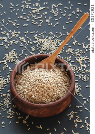 Brown rice in a wooden bowl with wooden or bamboo spoon 80172921