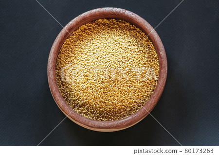 A cereals millet in wooden bowls top view 80173263