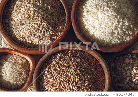 Set of different types of rice and cereals in wooden bowls 80174345