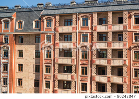 Finishing works on the facade of a new residential buildings 80242847