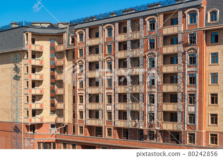 Finishing works on the facade of a new residential buildings Finishing works on the facade of a new residential buildings 80242856