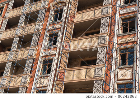 Finishing works on the facade of a new residential buildings Finishing works on the facade of a new residential buildings 80242868