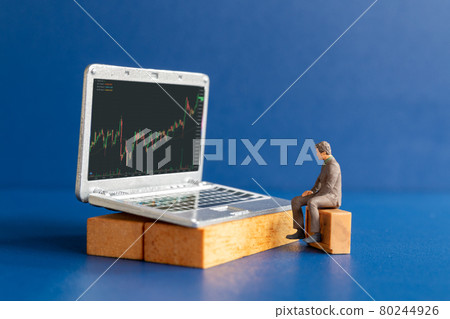 Miniature people, Business people and laptop featuring stock tickers Miniature people, Business people and laptop featuring stock tickers 80244926