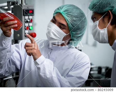 Nutritionists checking the quality of the herbal drinks check the quality of drink basil seed produces on a conveyer belt before distribution to market business. 80245009