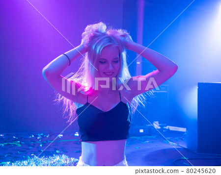 Portrait of beautiful DJ girl standing in the front of the decks. Party and holiday style.. Portrait of beautiful DJ girl standing in the front of the decks. Party and holiday style.. 80245620