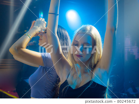 Portrait of two young beautiful DJ girl standing in the front of the decks. Party and holiday style.. Portrait of two young beautiful DJ girl standing in the front of the decks. Party and holiday style.. 80245672