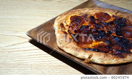 Burnt pizza on a wooden plate Burnt pizza on a wooden plate 80245974
