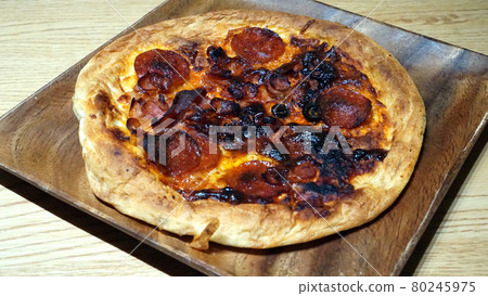 Burnt pizza on a wooden plate Burnt pizza on a wooden plate 80245975