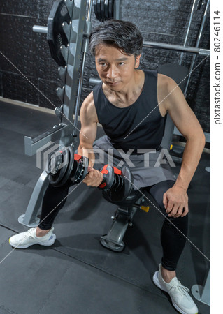 Middle-aged man training with dumbbells at the gym 80246114