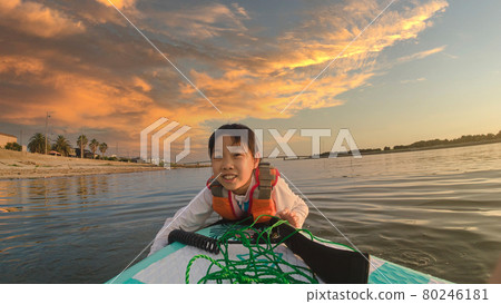 A cute child playing SUP board in the summer sea 80246181