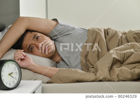 Depressed young Asian man lying in bed cannot sleep from insomnia 80246329