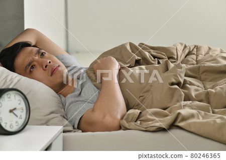 Depressed young Asian man lying in bed cannot sleep from insomnia 80246365