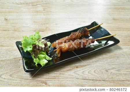 grilled pork dressings spicy sauce stabbing in wooden stick with vegetable on plate grilled pork dressings spicy sauce stabbing in wooden stick with vegetable on plate 80246372