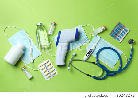 Medical tools and thermometer gun on green background Medical tools and thermometer gun on green background 80248272
