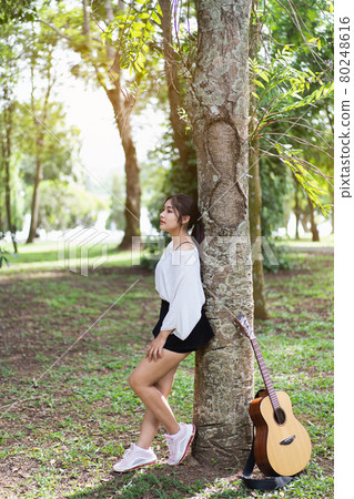 beautiful girl playing guitar at the garden beautiful girl playing guitar at the garden 80248616