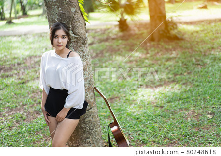 beautiful girl playing guitar at the garden beautiful girl playing guitar at the garden 80248618