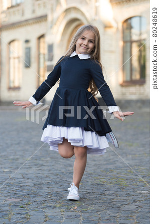 Happy small ballet dancer in school uniform balance on leg outdoors, ballerina Happy small ballet dancer in school uniform balance on leg outdoors, ballerina 80248619
