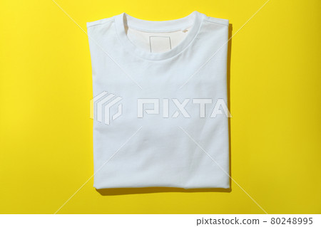 Folded sweatshirt on yellow background, space for text 80248995