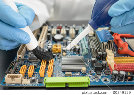 Technician use brush and air blower ball to clean dust in circuit board computer. Repair upgrade and maintenance technology. Technician use brush and air blower ball to clean dust in circuit board computer. Repair upgrade and maintenance technology. 80249139