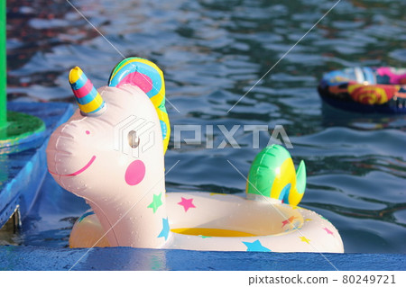 A swimming circle in the form of a unicorn is floating in the pool. A swimming circle in the form of a unicorn is floating in the pool. 80249721