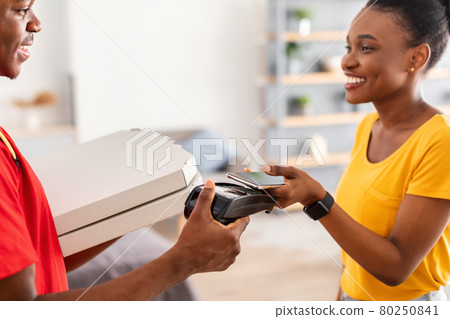 Lady Putting Smartphone To Terminal Paying Courier For Pizza Indoors Lady Putting Smartphone To Terminal Paying Courier For Pizza Indoors 80250841