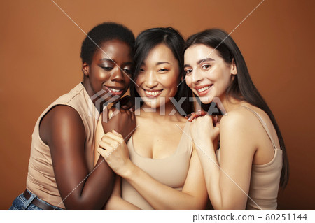 young pretty asian, caucasian, afro woman posing cheerful together on brown background, lifestyle diverse nationality people concept young pretty asian, caucasian, afro woman posing cheerful together on brown background, lifestyle diverse nationality people concept 80251144