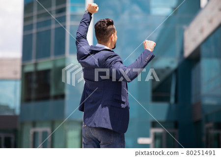 Back view of businessman in formal suit raising fists up 80251491