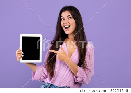 Check this.Cheerful armenian woman holding and pointing at digital tablet with black blank screen, purple background Check this.Cheerful armenian woman holding and pointing at digital tablet with black blank screen, purple background 80251546