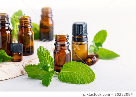 amber bottles with fresh mint leaves 80252094